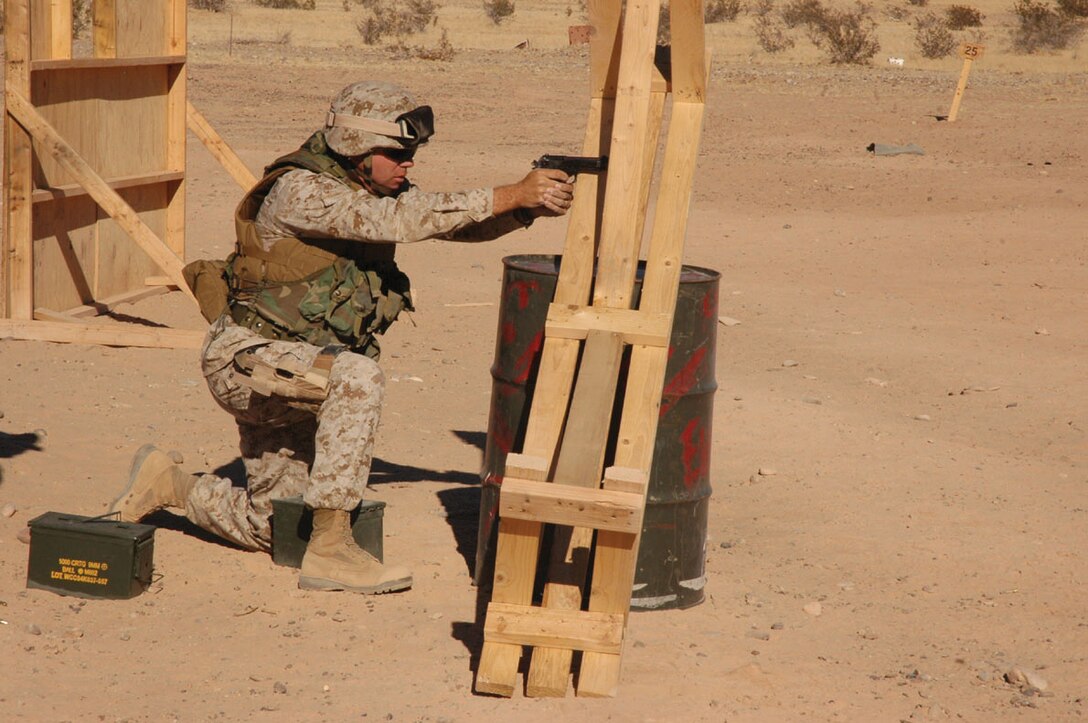 Master Sgt. Shawn Stevens, Marine Air Control Squadron 1 radar technician and native of Sequin, Wash., takes aim and fires from behind an oil drum and bench barricade at the enhanced marksmanship program range on the Barry M. Goldwater Range located southeast of the air station Nov. 17. Marines like Stevens were forced to negotiate the obstacle course, firing from behind objects at ranges from 15 to 50 yards, while carrying ammo cans full of rocks to simulate carrying ammunition on the battlefield.