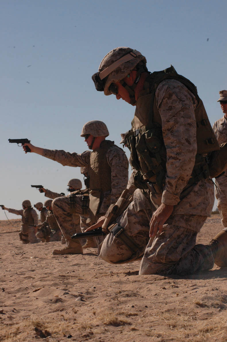 Master Sgt. Shawn Stevens (right), Marine Air Control Squadron 1 radar technician and native of Sequin, Wash., performs remidial action on his M-9 pistol during known-distance practice at the enhanced marksmanship program range on the Barry M. Goldwater Range located southeast of the air station Nov. 17. Marines were taught ways to perform remidial action on their weapons one-handed in case they are ever injured in a combat environment. Training lasted six days, preparing the MACS-1 security company Marines for a deployment to Iraq early next year. Training included both the M-9 and the M-16A2 service rifle. Marines firing on the EMP course trained for some of the conditions that they will encounter overseas.