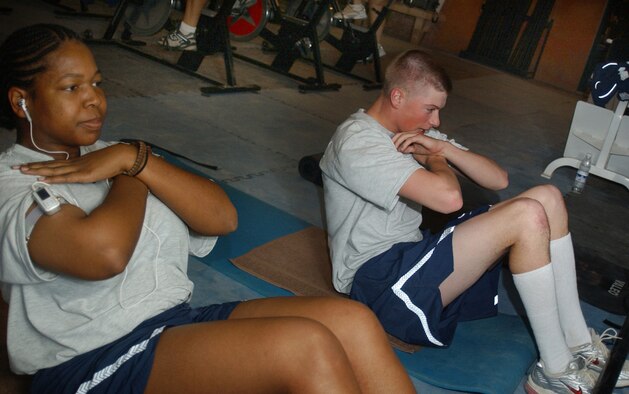 ALI BASE, Iraq (AFPN) -- Staff Sgt. Paula Spruill (left) and Airman 1st Class Andrew Warnamant exercise in preparation for their physical fitness test. Sergeant Spruill is an equipment management liaison craftsman assigned to the 407th Expeditionary Logistics Squadron. Airman Warnamant is an engineering assistant journeyman with the 732nd Expeditionary Civil Engineer Squadron. (U.S. Air Force photo by Tech. Sgt. Paul Dean) 