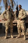 BAGHDAD INTERNATIONAL AIRPORT, Iraq -- Airmen 1st Class Travis (left) and Terence Mimms are identical twins deployed here from separate bases in Florida.  Travis, who works in supply, deployed first from Hurlburt Field, Fla., and did not know his twin was deploying to the same location.  Terence deployed from Eglin Air Force Base, Fla., where he works in security forces.  (U.S. Air Force photo by Master Sgt. Randy L. Mitchell)



