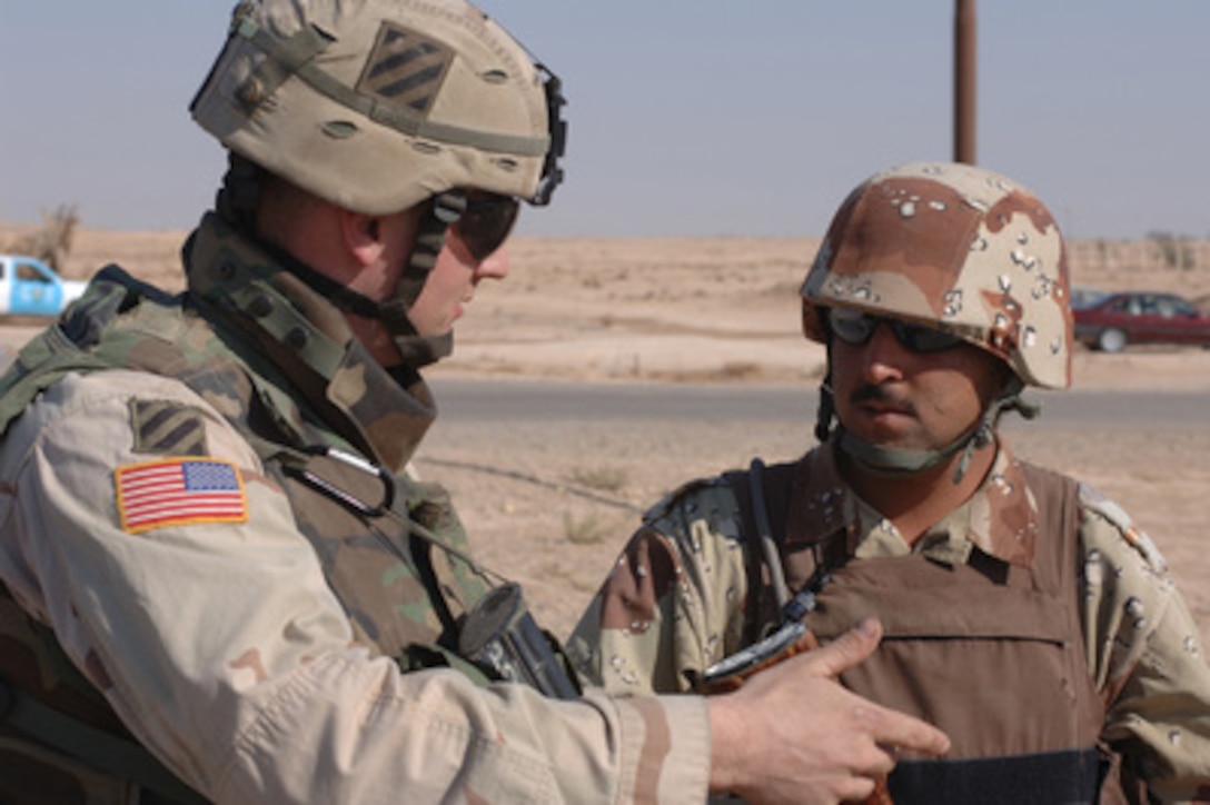 U.S. Army 1st Lt. Scott Lorenzen talks with Iraqi Army Sgt. Mohomed Qassim during a joint security operation in Adwar, Iraq, on Nov. 15, 2005. Lorenzen is attached to the Army's 3rd Infantry Division, while Qassim is attached to the 4th Company, 1st Battalion, 1st Brigade of the Iraqi Army. 