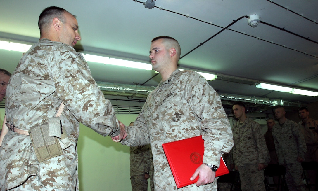 Lieutenant Col. Andrew Shorter, commanding officer of Marine Fighter Attack Squadron 223 congratulates Cpl. Adam Huenke, an intelligence Marine with VMA-223, on finishing second in the squadron?s deployed Corporal?s Leadership Course.