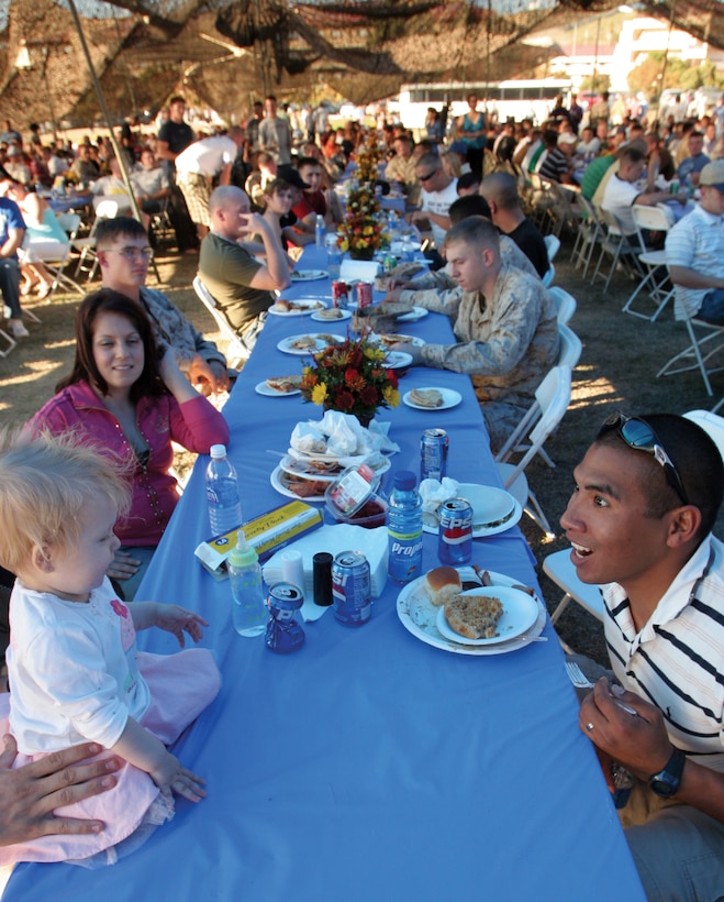 051119-M-7082F-008::n::CAMP PENDLETON, Calif. -- Marines and sailors of 2nd Battalion, 5th Marine Regiment, 1st Marine Division enjoy an early Thanksgiving dinner with family members who have travelled from all corners of the country to meet up with their fathers, husbands, sons and brothers before they make another deployment to Iraq in early December. More than 100 Albertson's associates from 18 local stores as well as a number of other volunteers from various local organizations contributed to feeding the servicemembers and their families. (Official U.S. Marine Corps photo by Lance Cpl. Patrick J. Floto)(released)