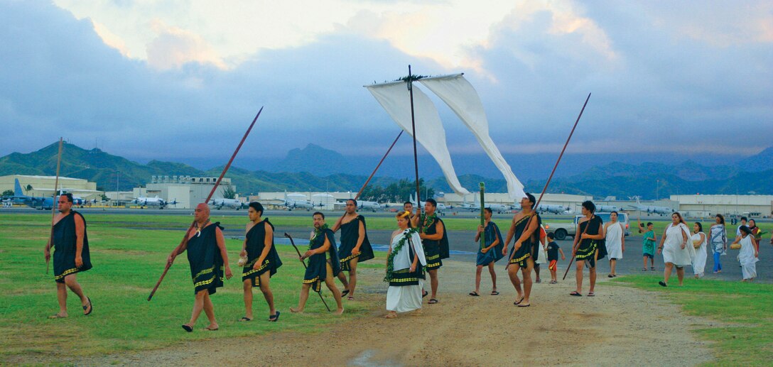 Makahiki participants parade with the akua loa toward Pyramid Rock Beach aboard Marine Corps Base Hawaii to mark the beginning of the Makahiki season. A warrior near the front of the procession periodically blows on a conch shell to call everyone within hearing distance to the opening ceremonies. The Makahiki season coincides with the Hawaiian star-calendar new year and is a celebration of the harvest.