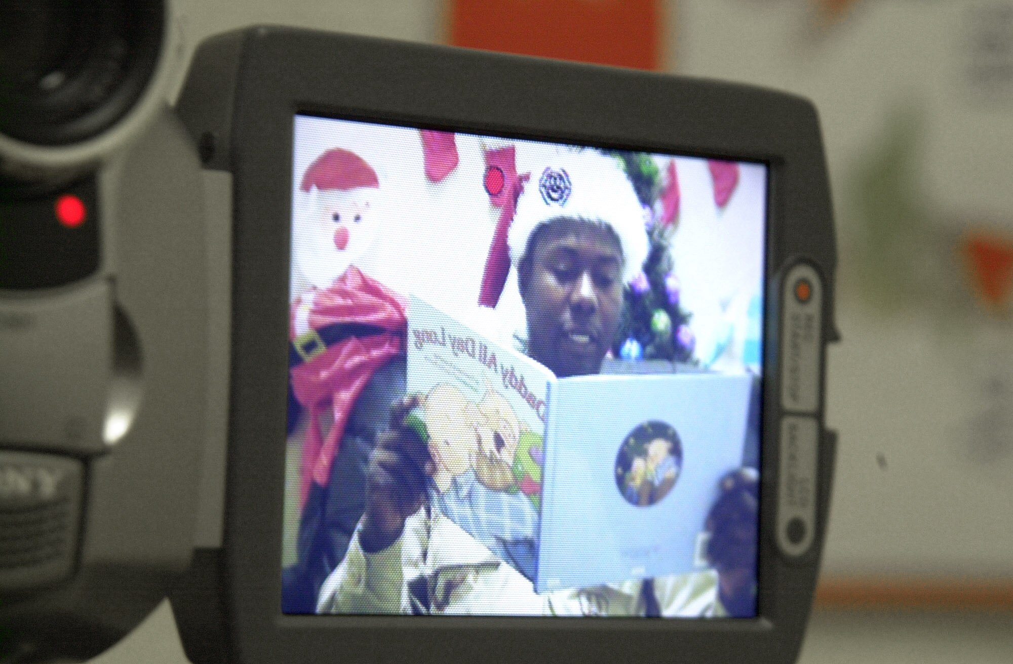 SOUTHWEST ASIA (AFPN) -- Tech. Sgt. Anthony Reeves reads a story to his child to be sent back home. Sergeant Reeves is deployed from the 43rd Airlift Wing at Pope AFB, N.C.  (U.S. Air Force photo by Senior Airman Cassandra Locke)