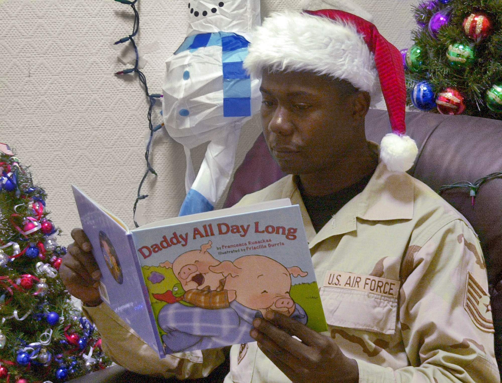 SOUTHWEST ASIA (AFPN) -- Tech. Sgt. Anthony Reeves reads "Daddy All Day Long" to his children back home at Pope AFB, N.C., where he is deployed from. The Story Time Video Program gives deployed members the opportunity to still be a part of their children's lives by reading to them via video.  Sergeant Reeves is with the 379th Expeditionary Aeromedical Evacuation Squadron. (U.S. Air Force photo by Senior Airman Cassandra Locke) 