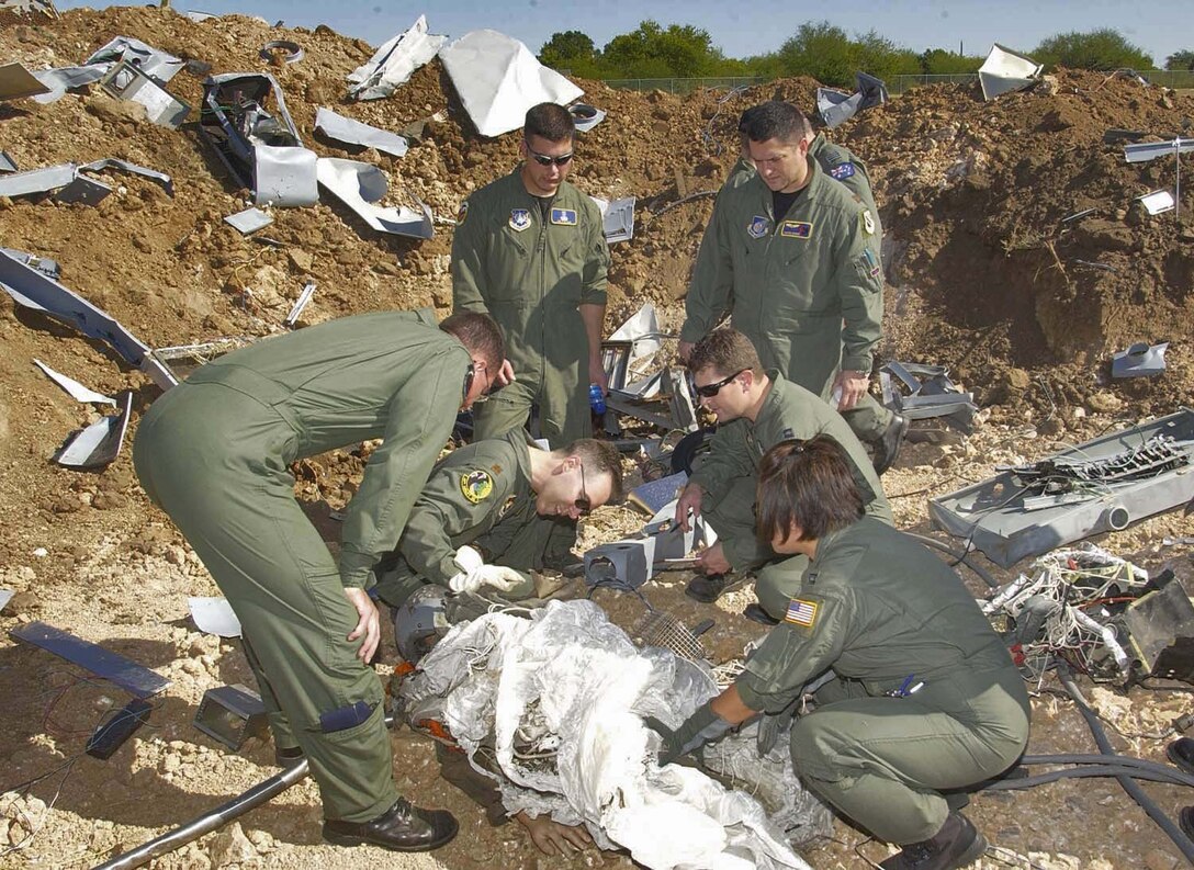 BROOKS CITY-BASE, Texas (AFPN) -- Students of the Aircraft Mishap Investigation and Prevention course at the U.S. School of Aerospace Medicine sift through the "wreckage" at a mock aircraft crash site.  The site is used in field exercises to give students a realistic idea what an actual site might be like. The course recently underwent changes, moving from a primarily lecture-based format to a more hands-on, problem-based learning approach. (Air Force photo by Tech. Sgt. Alfonso Ramirez)