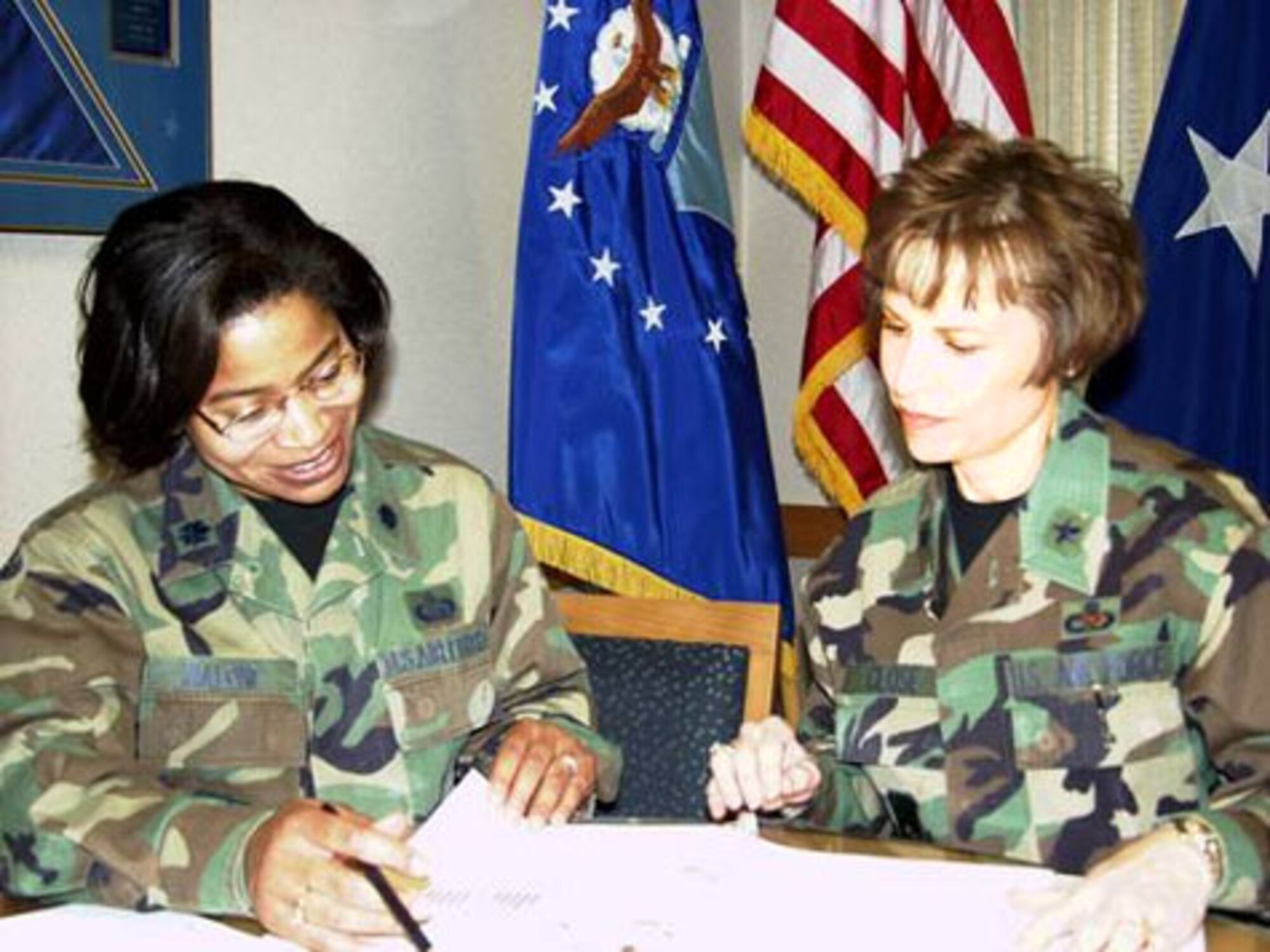 WRIGHT-PATTERSON AIR FORCE BASE, Ohio (AFMCNS) -- The AFMC Force Shaping briefing team, Lt. Col. Cheryl Malone (left), AFMC/A1 and Brig. Gen. Kathie Close, AFMC/A7, review the briefing book before the start of another trip to AFMC bases. The duo will have all affected AFMC officers briefed by Nov. 18. (AF photo by Ron Scharven)