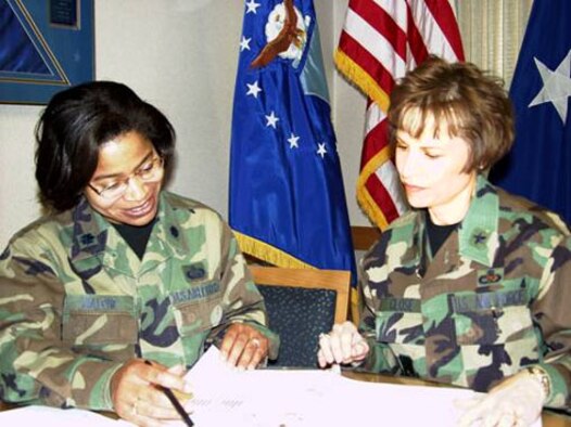 WRIGHT-PATTERSON AIR FORCE BASE, Ohio (AFMCNS) -- The AFMC Force Shaping briefing team, Lt. Col. Cheryl Malone (left), AFMC/A1 and Brig. Gen. Kathie Close, AFMC/A7, review the briefing book before the start of another trip to AFMC bases. The duo will have all affected AFMC officers briefed by Nov. 18. (AF photo by Ron Scharven)
