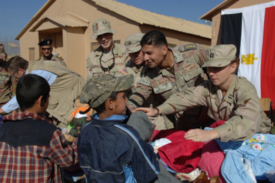 U.S. Army soldiers from Task Force Strength and Egyptian soldiers give donated clothes to Afghan children during a joint humanitarian aid mission at Bagram Air Base, Afghanistan, on Nov. 17, 2005. Task Force Strength conducts humanitarian missions along with coalition forces to aid the Afghan people. 