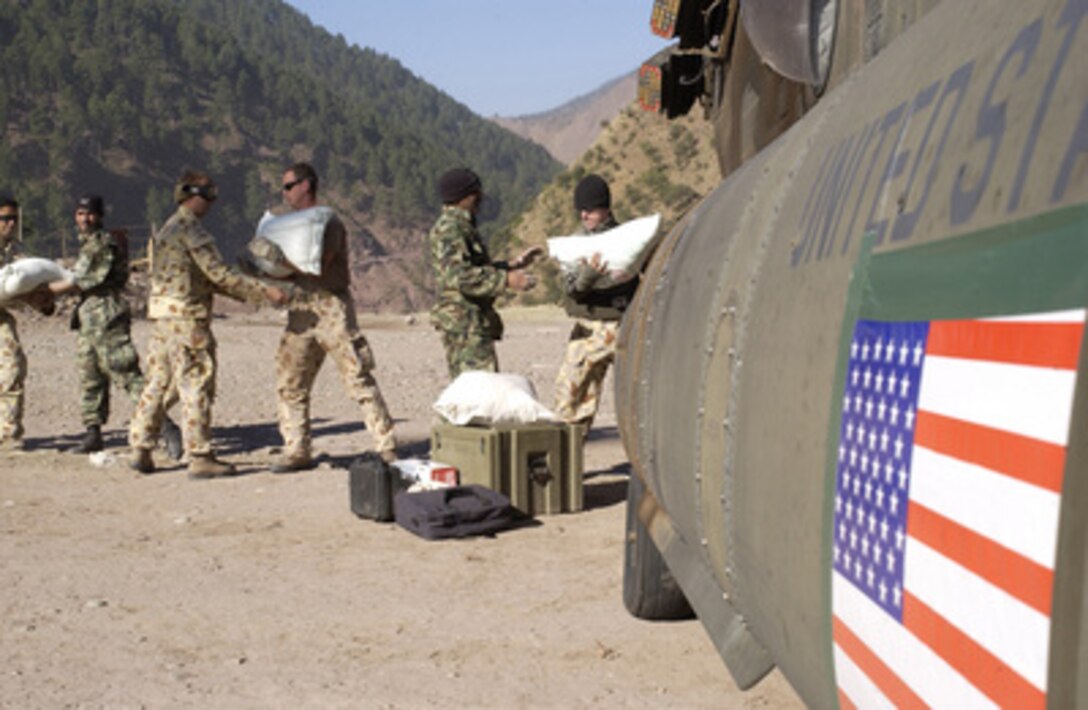 Australian and Pakistani soldiers unload humanitarian relief supplies from a U.S. Army CH-47D Chinook helicopter at Dhanni, Pakistan, on Nov. 19, 2005. The Department of Defense is supporting the State Department by providing disaster relief supplies and services following the massive earthquake that struck Pakistan and parts of India and Afghanistan. 