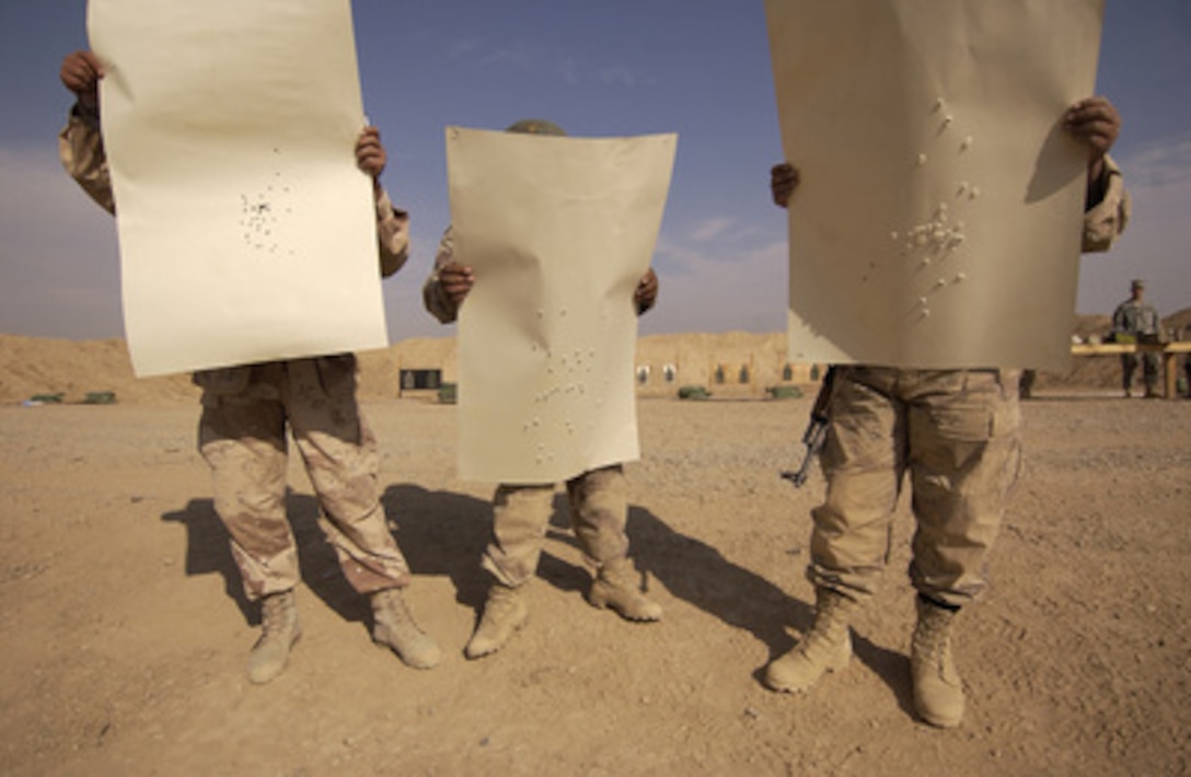 Three Iraqi Army soldiers look over their targets after trying to qualify on the AK-47 weapon during a weapons class conducted by U.S. Army soldiers at Forward Operations Base McHenry, Iraq, on Nov. 20, 2005. Soldiers from the 101st Airborne of Fort Campbell, Ky., are training the Iraqi soldiers in weapons handling and marksmanship. 