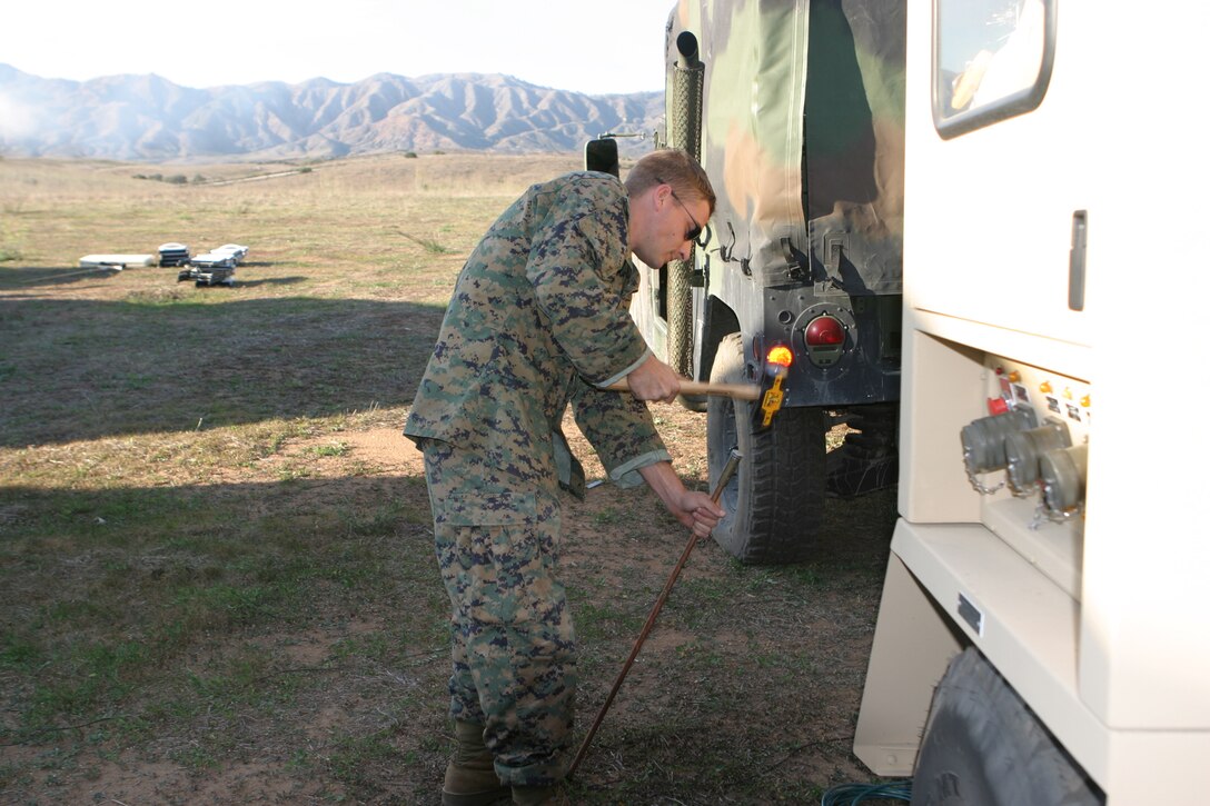 CAMP PENDLETON, Calif. (Nov 21, 2005) - Sgt. Robert J. Savicke, a motor transport mechanic for the 15th Marine Expeditionary Unit pounds a copper stake into the ground while setting up a generator. The 15th MEU conducted a Combat Operation Center Exercise in the 25 Area here.  (Official USMC photo by Gunnery Sgt. Rhonda Mera)(Released)