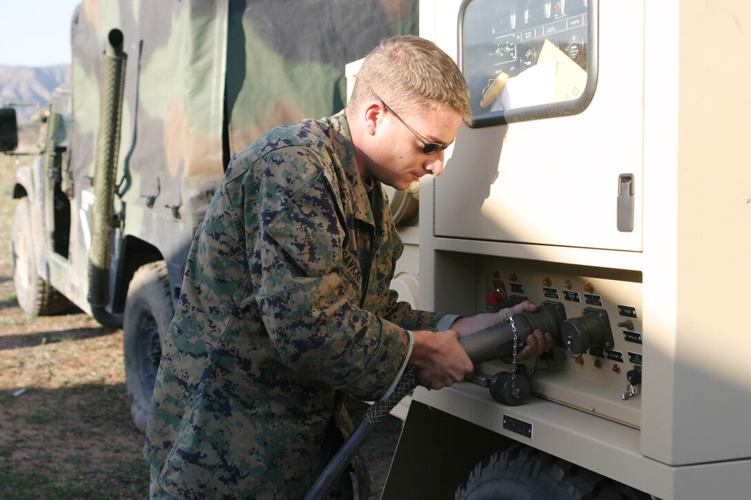 Sgt. Robert J. Savicke, a motor transport mechanic for the 15th Marine Expeditionary Unit, connects power cables to the generator. The 15th MEU conducted a Command Operation Center Excursive within the 25 Area here.