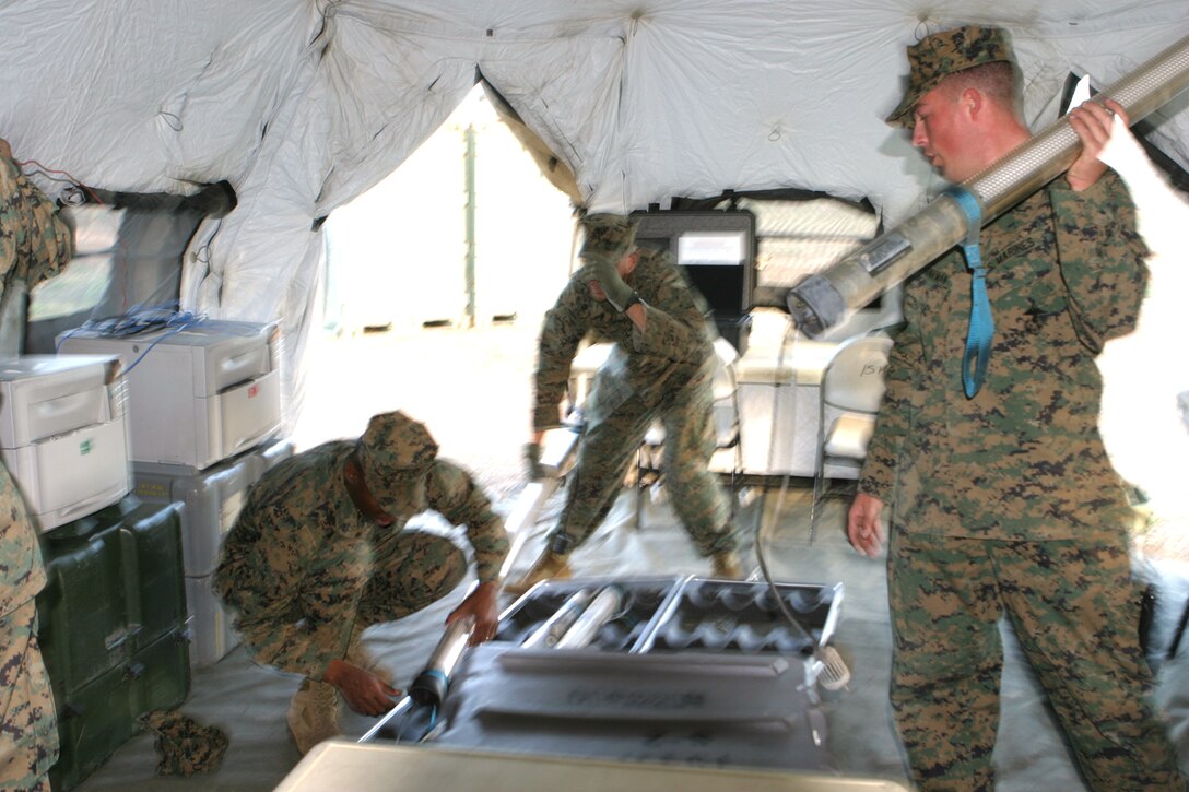Sgt Corey A. Schwendeman (left), an intelligence analyst for the 15th Marine Expeditionary Unit helps set up the intelligence section's Deployable Rapid Assembly Shelter tent.  The 15th MEU conducted a Command Operation Center Exercise in the 25 Area here.