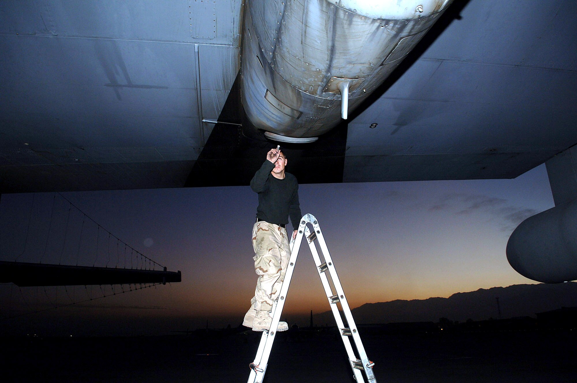 BAGRAM AIR BASE, Afghanistan (AFPN) -- Senior Airman Adam Davis inspects an EC-130H Compass Call's engine intakes and exhaust ports for cracks and debris damage before a combat sortie. In the last 18 months, the 41st Expeditionary Electronic Combat Squadron flew more than 3,000 combat flying hours--the equivalent of covering the state of Texas with electronic signals 28 times. Airman Davis deployed from Davis-Monthan Air Force Base, Ariz.  (U.S. Air Force photo by Capt. James H. Cunningham) 