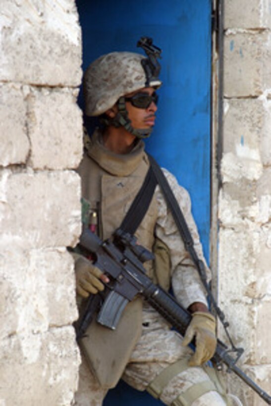U.S. Marine Corps Lance Cpl. Hector Figueroa takes up a position in a doorway while Marines and Iraqi Army soldiers search for weapons during operations in Zaidon, Iraq, on Nov. 15, 2005. The Marines of the 2nd Marine Regiment and soldiers with the 1st Division of the Iraqi Army are conducting operations in Zaidon to clear out insurgent forces and to prevent them from using Zaidon as a staging area in the future. 