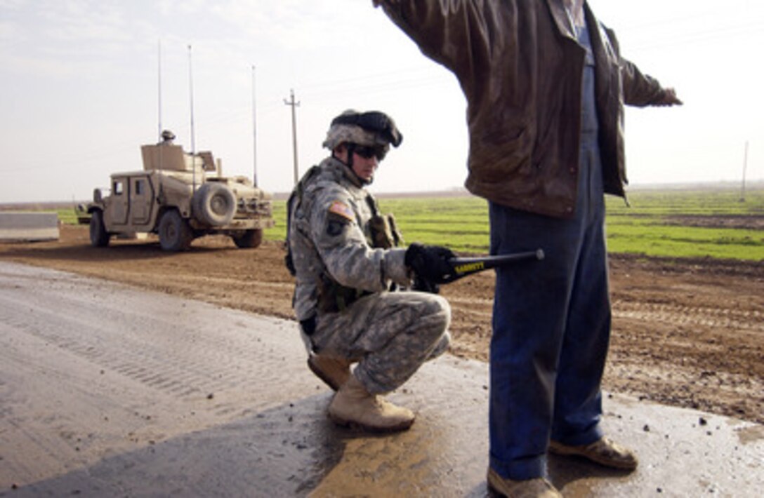 Army Spc. Jonathan Terrian uses a wand to check for any hidden metal objects as he searches an Iraqi man stopped at a checkpoint on route Cherry in Iraq on Nov. 22, 2005. U.S. and Iraqi soldiers are searching the man's car at the routine stop for weapons and explosives. Terrain is attached to 1st Platoon, Charlie Company, 101st Airborne of Fort Campbell, Ky. 
