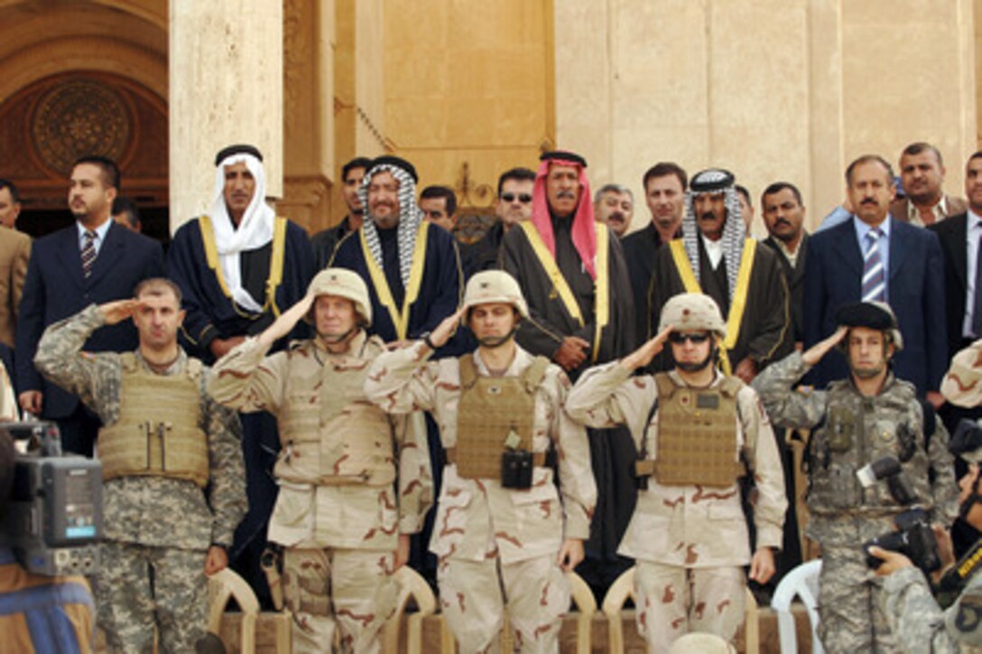 Iraqi sheiks stand and U.S. Army soldiers salute as the Iraqi National Anthem is played during the Iraqi flag raising during turnover ceremonies at the former Forward Operating Base Danger in Tikrit, Iraq, on Nov. 22, 2005. Coalition forces are transferring the former Iraqi dictator Saddam Hussein's palace in Tikrit to the new Iraqi government. 