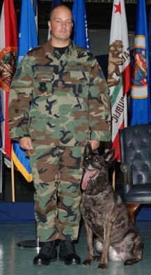 EGLIN AIR FORCE BASE, Fla. (AFMCNS) -- Tech. Sgt. Martin Ratkowski, a dog handler with the 96th Security Forces Squadron, stands with his dog, Toby, during Toby's retirement ceremony. Toby, a Dutch Shephard, retired after 49 dog years of distinguished services in a special ceremony at the Air Armament Museum. (Courtesy photo)