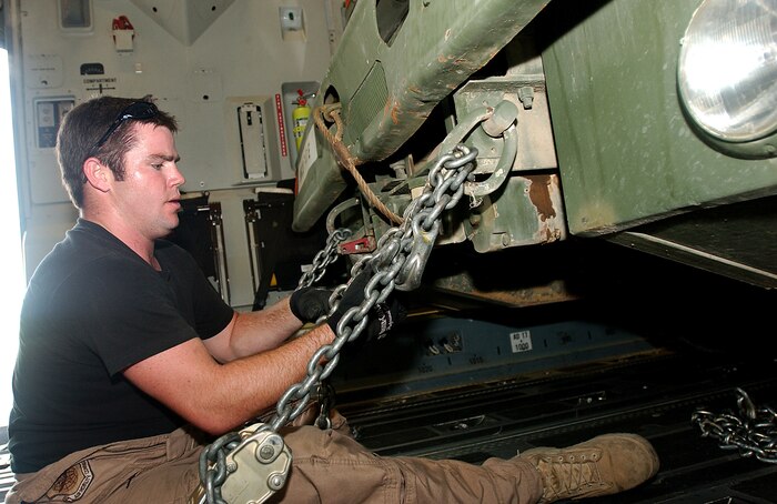 CAMP LEMONIER, Djibouti (AFPN) -- Senior Airman Jake Wyatt connects chains to a well rig inside a C-17 Globemaster III. The Airman is one of many Airmen supporting the Army's operations in the Horn of Africa. Airman Wyatt is a loadmaster from the 14th Airlift Squadron at Charleston Air Force Base, S.C. (U.S. Air Force photo by Staff Sgt. Stephen Schester)