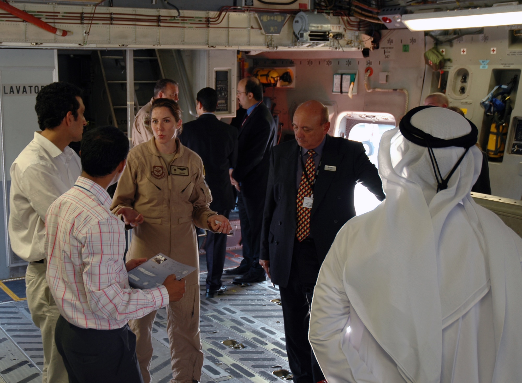DUBAI, United Arab Emirates--1st Lt Heather Swanson, an Air Force Reserve pilot assigned to the 315th Airlift Wing, Charleston AFB, S.C. reviews featurers of the C-17 Globemaster III with a group of Middle-Eastern men at the Dubai 2005 air show.