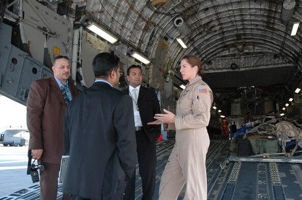 DUBAI, United Arab Emirates--1st Lt Heather Swanson, an Air Force Reserve pilot assigned to the 315th Airlift Wing, Charleston AFB, S.C. reviews features of the C-17 Globemaster III to a group a business men at the Dubai 2005 air show.
