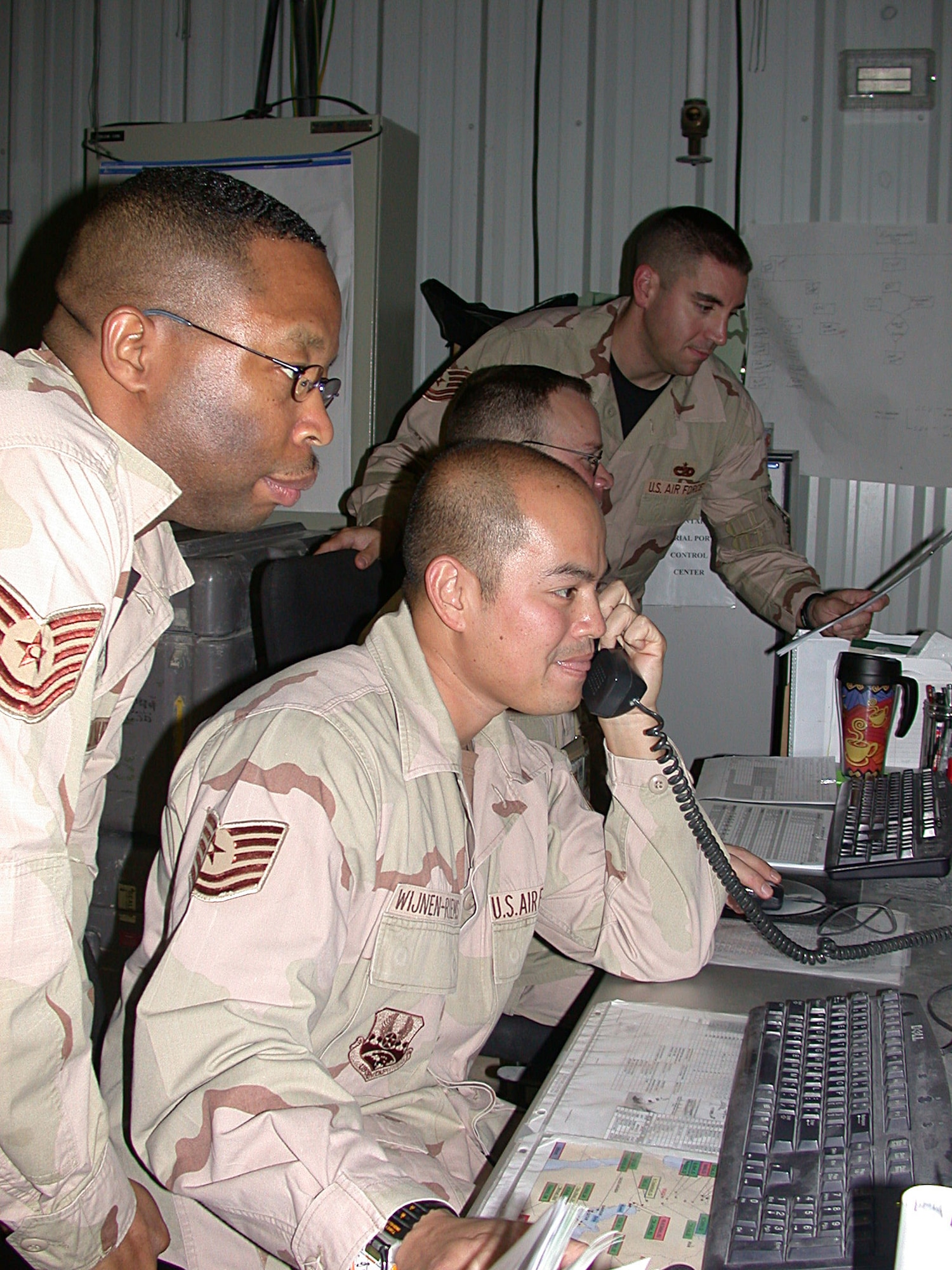 SOUTHWEST ASIA (AFPN) -- Tech. Sgts. Keith Callwood (left) and Maurice Wijnen-Riemes work on a cargo shipment at the U.S. Central Command Air Forces Aerial Port Control Center. Since the center opened in August, cargo backlogs have been reduced to less than 300 pallets per month. Sergeant Callwood is a an in-transit visibility cell controller. Sergeant Wijnen-Riemes is the cargo management section senior controller. (U.S. Air Force photo by Staff Sgt Alicia Prakash)
