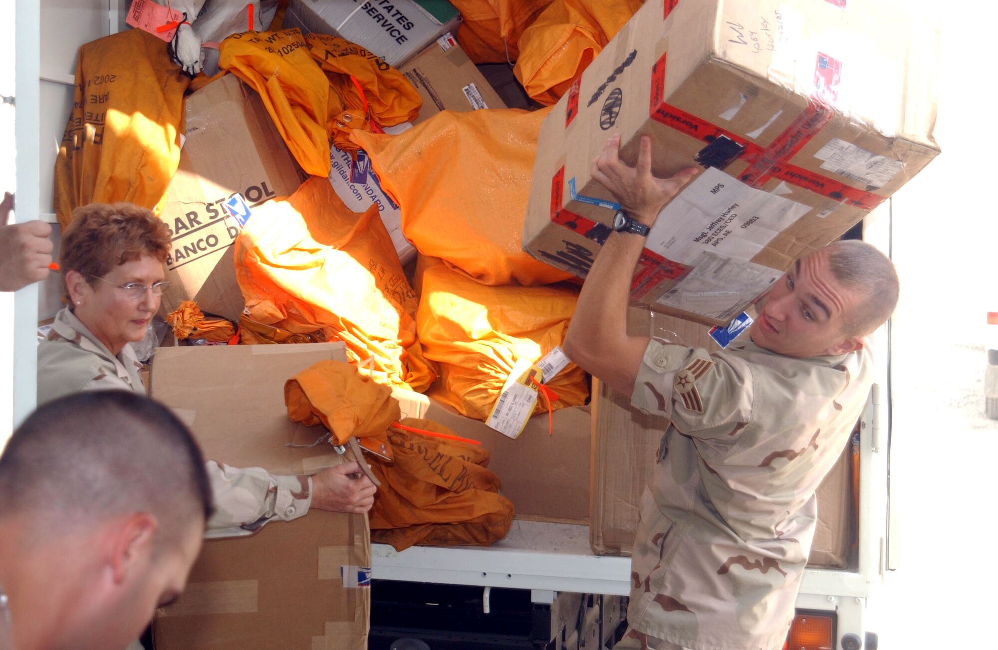 SOUTHWEST ASIA (AFPN) -- Senior Airman Michael Kohut and Master Sgt Denise Meyers unload mail from a mail truck at this forward-deployed location. Airman Kohut and Sergeant Meyers are part of a mail team responsible for receiving and sending mail for the 380th Air Expeditionary Wing's more than 1,400 servicemembers. (U.S. Air Force photo by Tech. Sgt. Mike Hammond)