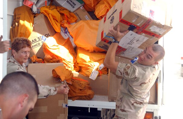 SOUTHWEST ASIA (AFPN) -- Senior Airman Michael Kohut and Master Sgt Denise Meyers unload mail from a mail truck at this forward-deployed location. Airman Kohut and Sergeant Meyers are part of a mail team responsible for receiving and sending mail for the 380th Air Expeditionary Wing's more than 1,400 servicemembers. (U.S. Air Force photo by Tech. Sgt. Mike Hammond)
