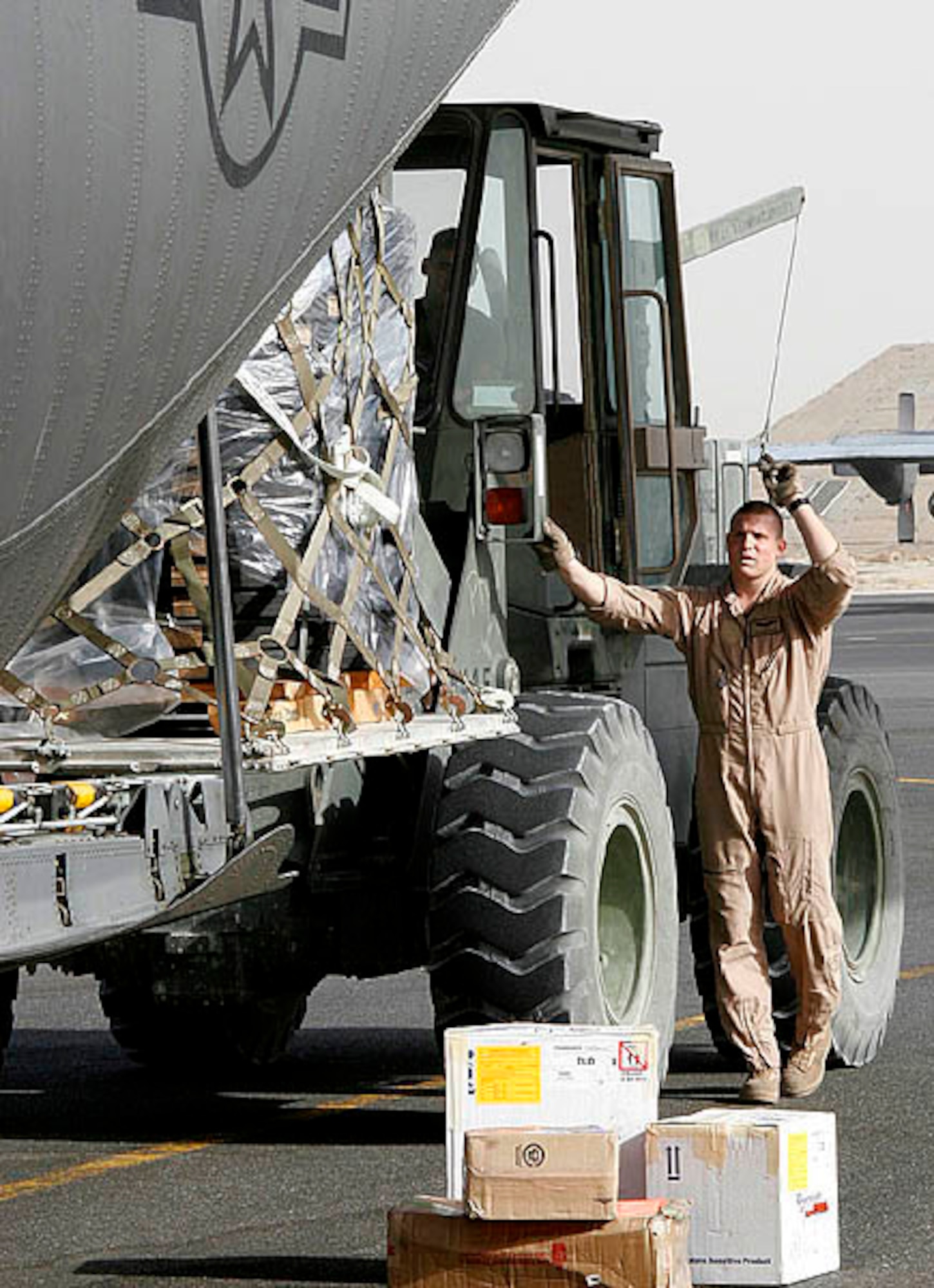 SOUTHWEST ASIA (AFPN) - A loadmaster guides the loading of cargo at the U.S. Central Command Air Forces Aerial Port Control Center. The new center, which operates around the clock, is divided into three sections: the passenger reservations, cargo management and in-transit visibility. The cargo management section moves more than 3,000 pallets of cargo a month. (U.S. Air Force photo by Lt. Col. Mark Naumann)