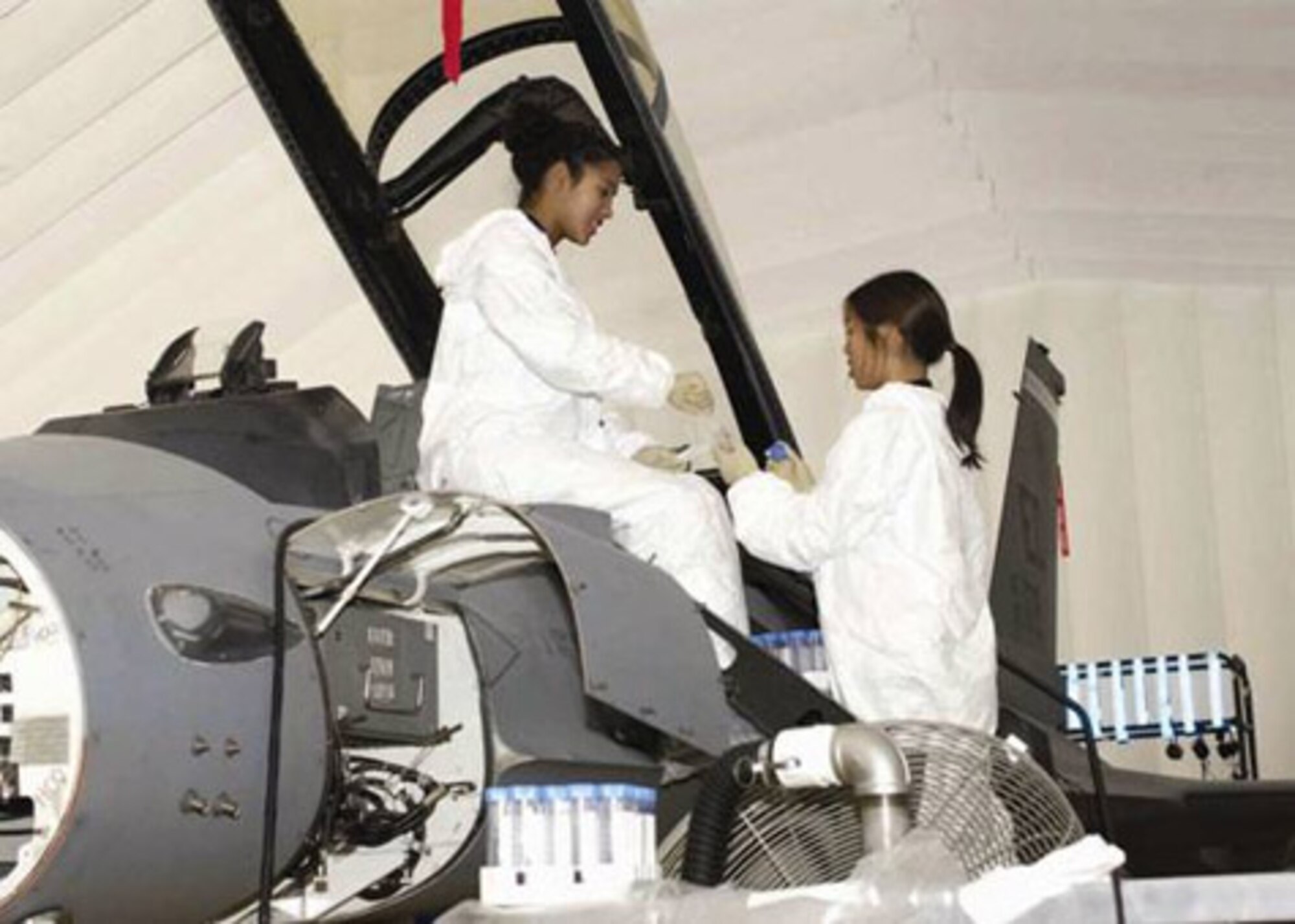 EDWARDS AIR FORCE BASE, Calif. (AFMCNS) -- Tina Slade and Jennifer 
Tanyatanaboon, microbiologists with Battelle, the lead contractor for the JSF 
decontamination project, prepare an F-16 for a biological (simulant) contamination trial. (Air Force photo by Jeffrey Youngblood)