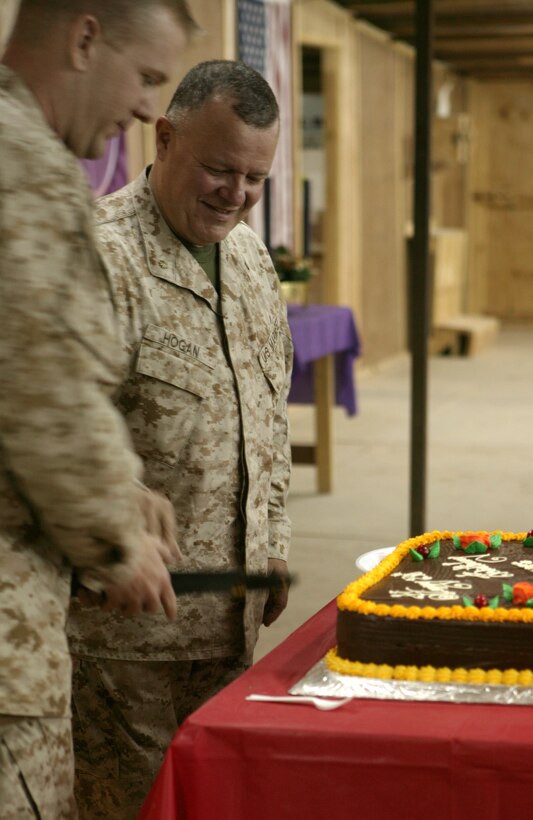 CAMP TAQADDUM, Iraq (Nov. 28, 2005) ? Lt. Michael R. Pipkin (left) and Lt. Cmdr. Timothy D. Hogan partake in a cake cutting ceremony here Nov. 28.  Sailors, Marines and Soldiers came together under one roof to celebrate the 230th Navy Chaplain Corps?s birthday. Although the ceremony was minus the company of loved ones from home, everyone was in good spirits to be celebrating their proud tradition with 2nd Marine Logistics Group (Forward). Pipkin is the chaplain for 8th Engineer Support Battalion, and Hogan is the chaplain for Combat Logistics Battalion-8, both with 2nd MLG (FWD).