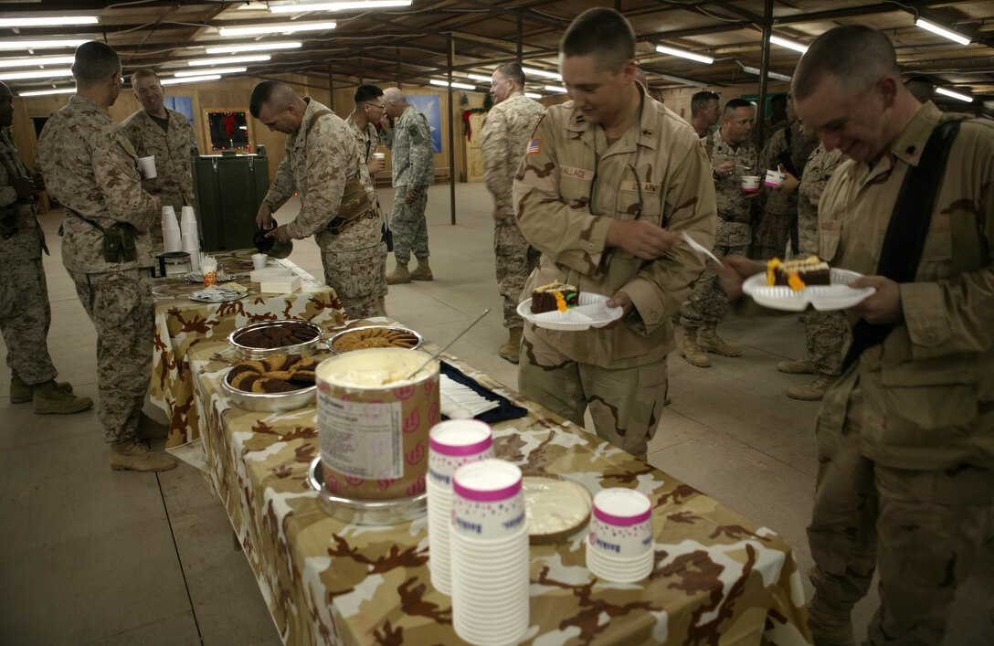 CAMP TAQADDUM, Iraq (Nov. 28, 2005) ? Service members enjoy cake, ice cream and coffee after a cake cutting ceremony here Nov. 28. Sailors, Marines and Soldiers came together under one roof to celebrate the 230th Navy Chaplain Corps?s birthday. Although the ceremony was minus the company of loved ones from home, everyone was in good spirits to be celebrating their proud tradition with 2nd Marine Logistics Group (Forward).