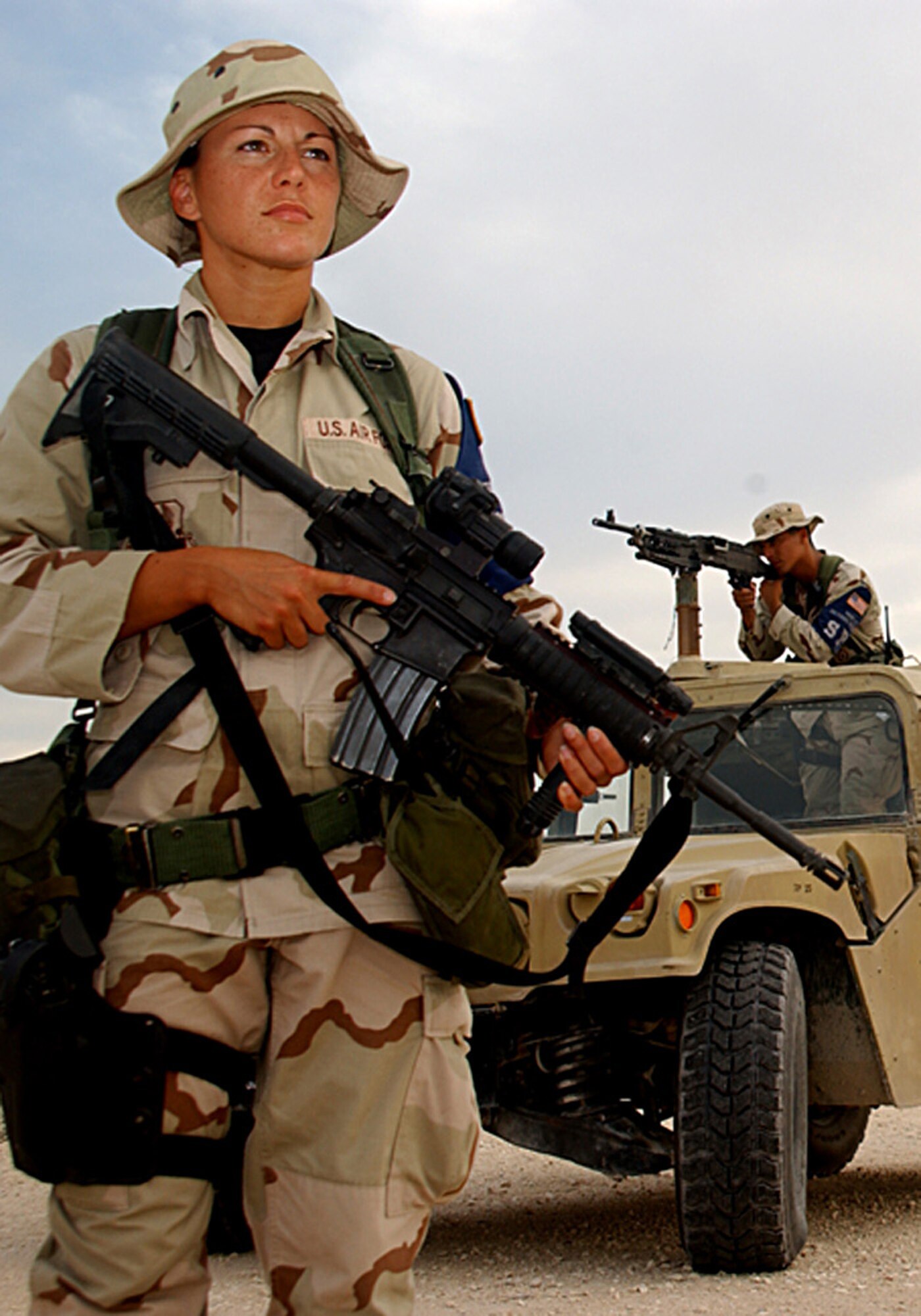 SOUTHWEST ASIA (AFPN) -- Airman 1st Class Carin Brigham stands ready to ensure base perimeter security here. Airman 1st Class Erick Martinez backs her up with a M240 machine gun. Both Airmen are in the 379th Expeditionary Security Forces Squadron. The security forces career is undergoing a transformation that will affect the total force. These changes will present the opportunity for other Airmen to participate in installation security. (U.S. Air Force photo by Tech.Sgt. Sarah R. Webb)