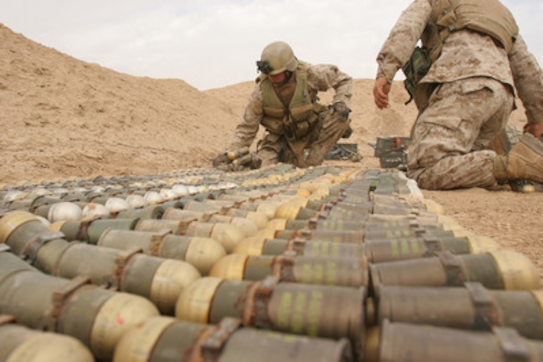 U.S. Marine Corps and U.S. Army explosive ordnance disposal technicians arrange unexploded ordnance for demolition at Camp Fallujah, Iraq, on Nov. 19, 2005. The confiscated ordnance came from weapons and munitions caches found in the area. 