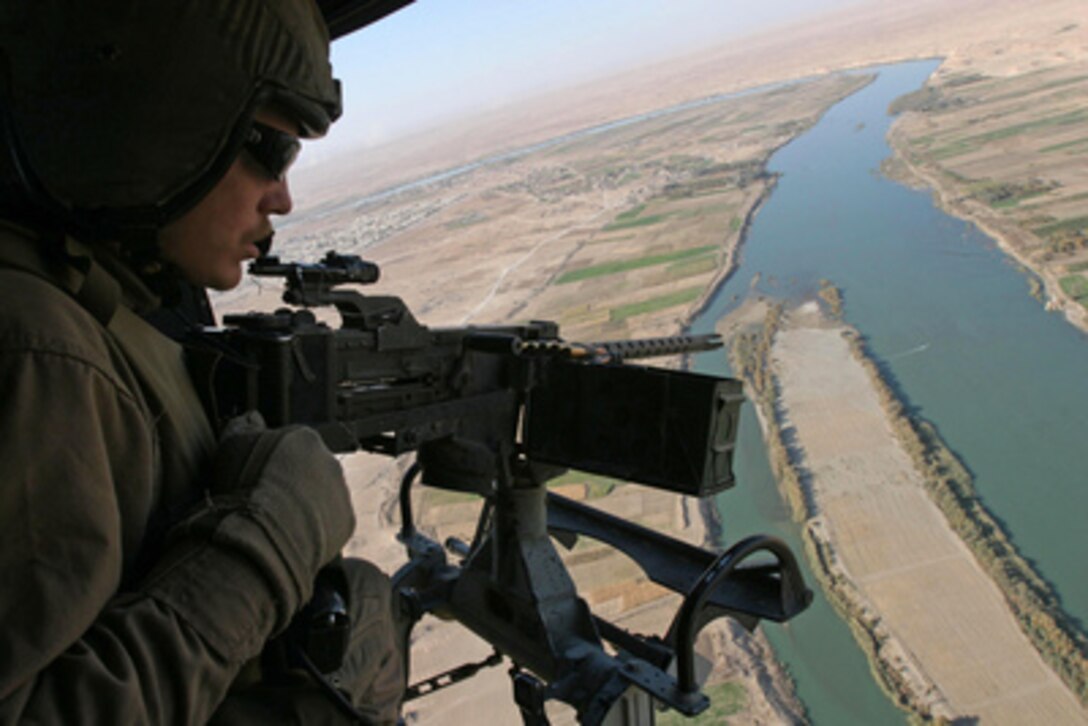 U.S. Marine Corps Cpl. Caleb Love watches for insurgent activity from the door of his UH-1N Huey helicopter while providing close air support for coalition forces engaging insurgents in the city of Ubadyi, Iraq, during Operation Steel Curtain on Nov. 16, 2005. Love is a Huey helicopter crew chief with Marine Light Attack Helicopter Squadron 369 of Camp Pendleton, Calif. 