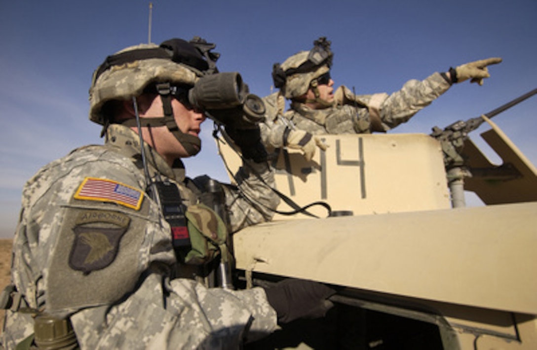 Two U.S. Army soldiers from the 101st Airborne scan the area ahead of them prior to linking up with soldiers from the Iraqi Army in Shumait Village, Iraq, on Nov. 27, 2005. The U.S. soldiers from 1st Platoon, Alpha Company, 1st Battalion, 327th Infantry Regiment, 101st Airborne Division of Fort Campbell, Ky., will conduct a joint foot patrol with Iraqi soldiers to show a presence and to search for insurgent activity. 