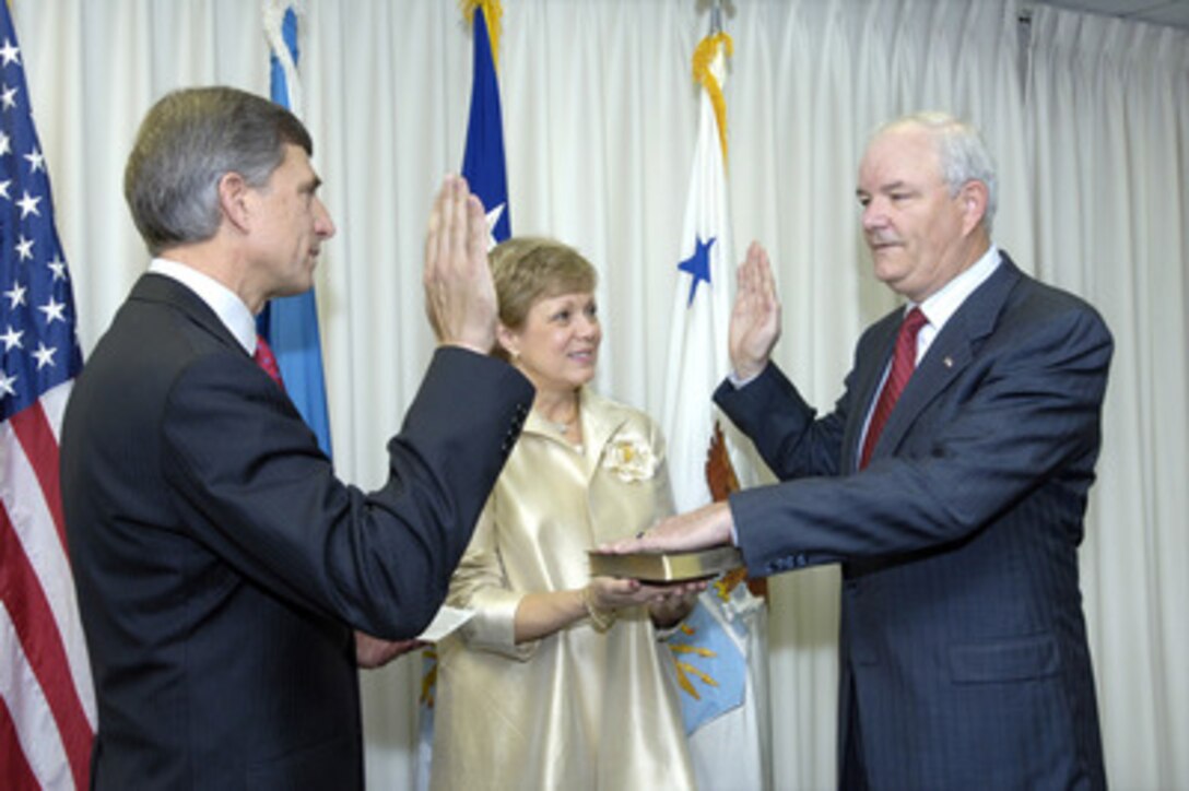 Michael W. Wynne (right) takes the oath of office as the 21st Secretary of the Air Force during a ceremony in the Pentagon on Nov. 28, 2005. Administering the oath is Under Secretary of the Air Force Ronald M. Sega (left) and holding the Bible is Barbara Wynne. 