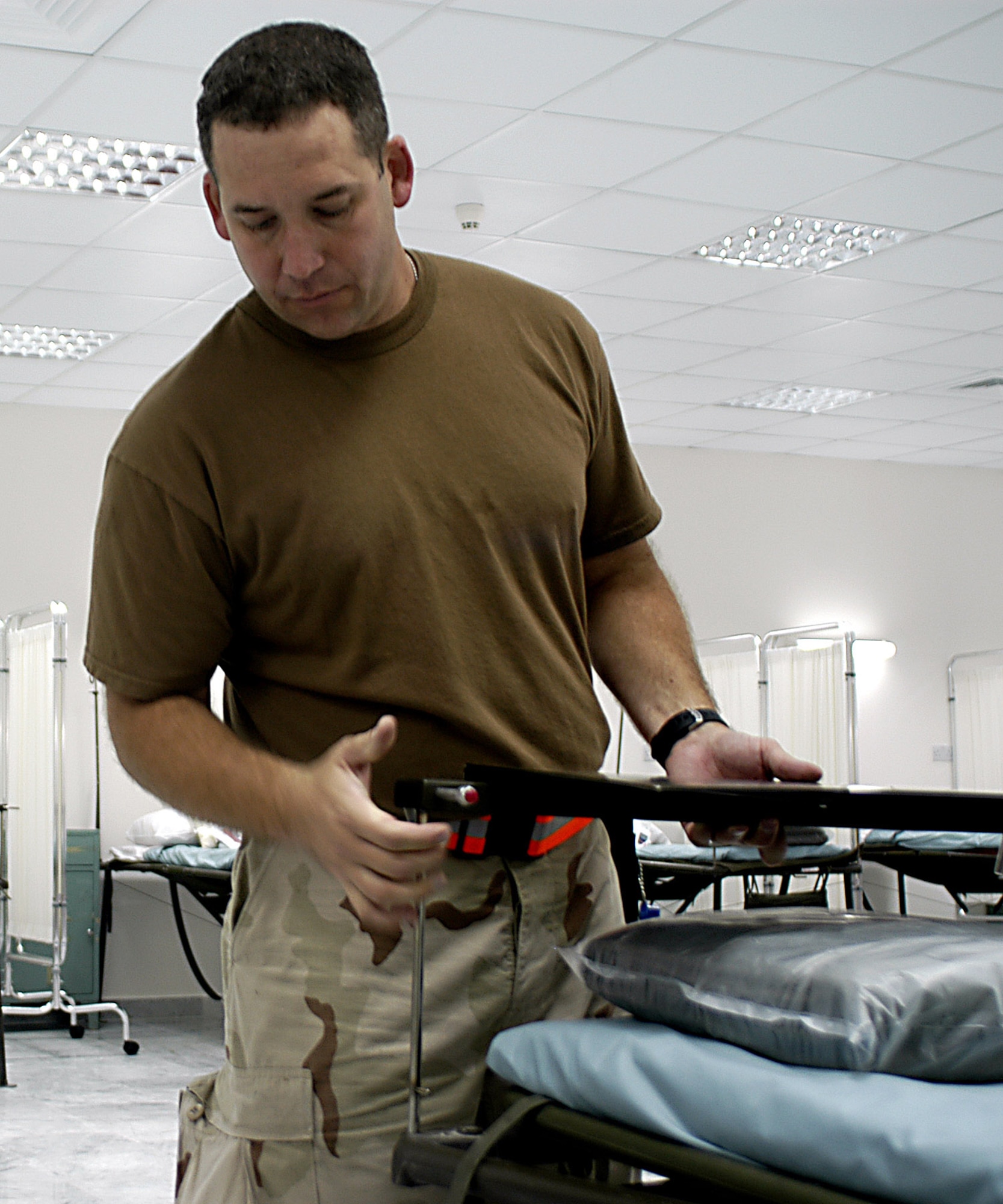 SOUTHWEST ASIA (AFPN) -- Senior Master Sgt. Anthony Weary installs a table top on a patient's bed in the new 386th Contingency Aeromedical Staging Facility.  More than 3,700 patients have been cared for in the facility since June 2004.   Sergeant Weary is the superintendent for the facility.  (U.S. Air Force photo by Tech. Sgt. Mark Getsy)