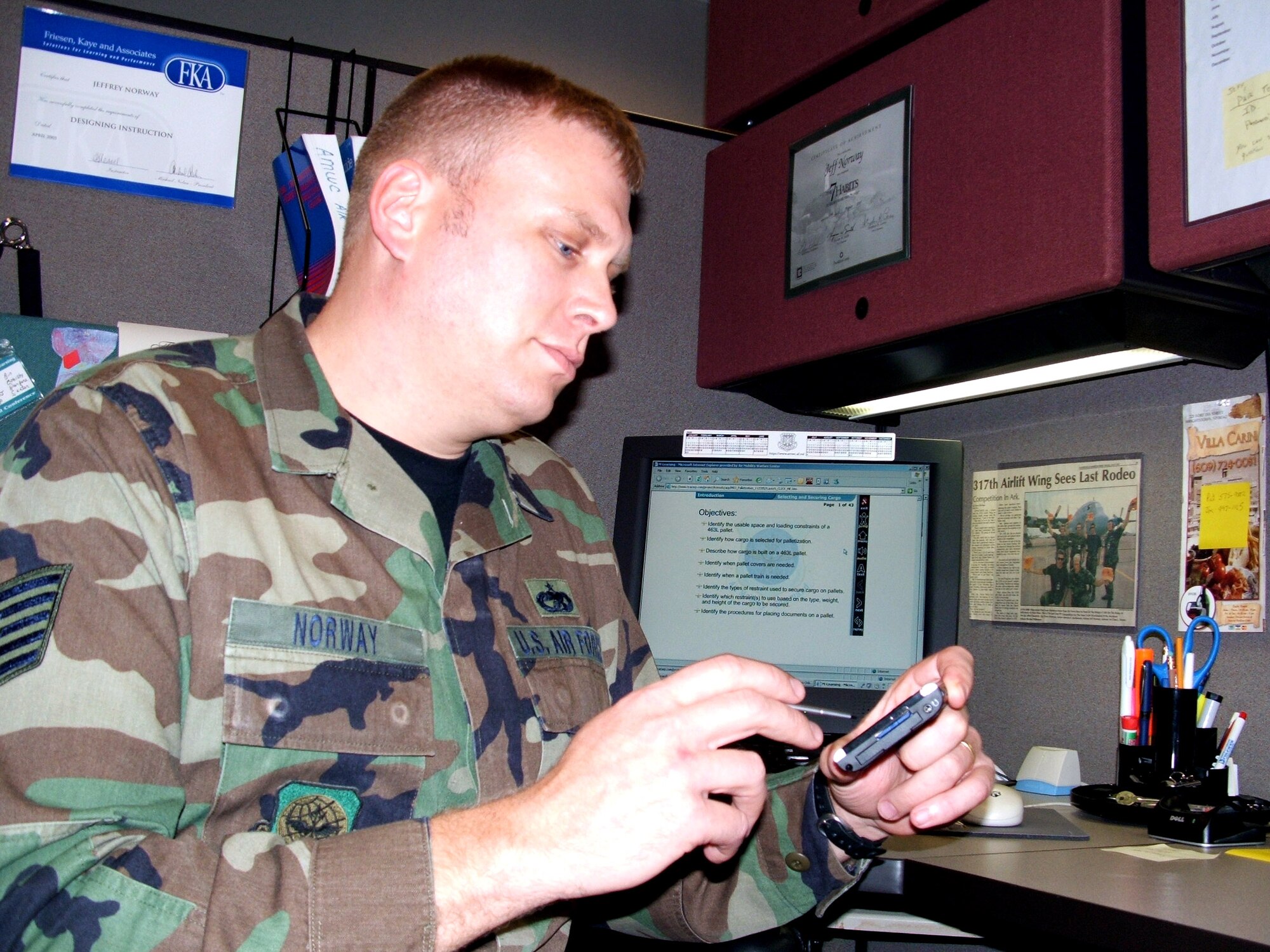 FORT DIX, N.J. (AFPN) -- Tech. Sgt. Jeff Norway programs a personal digital assistant device for use in the Air Mobility Warfare Center mobile learning initiative for the Air Force air transportation career field. (U.S. Air Force photo by Tech. Sgt. Scott T. Sturkol) 