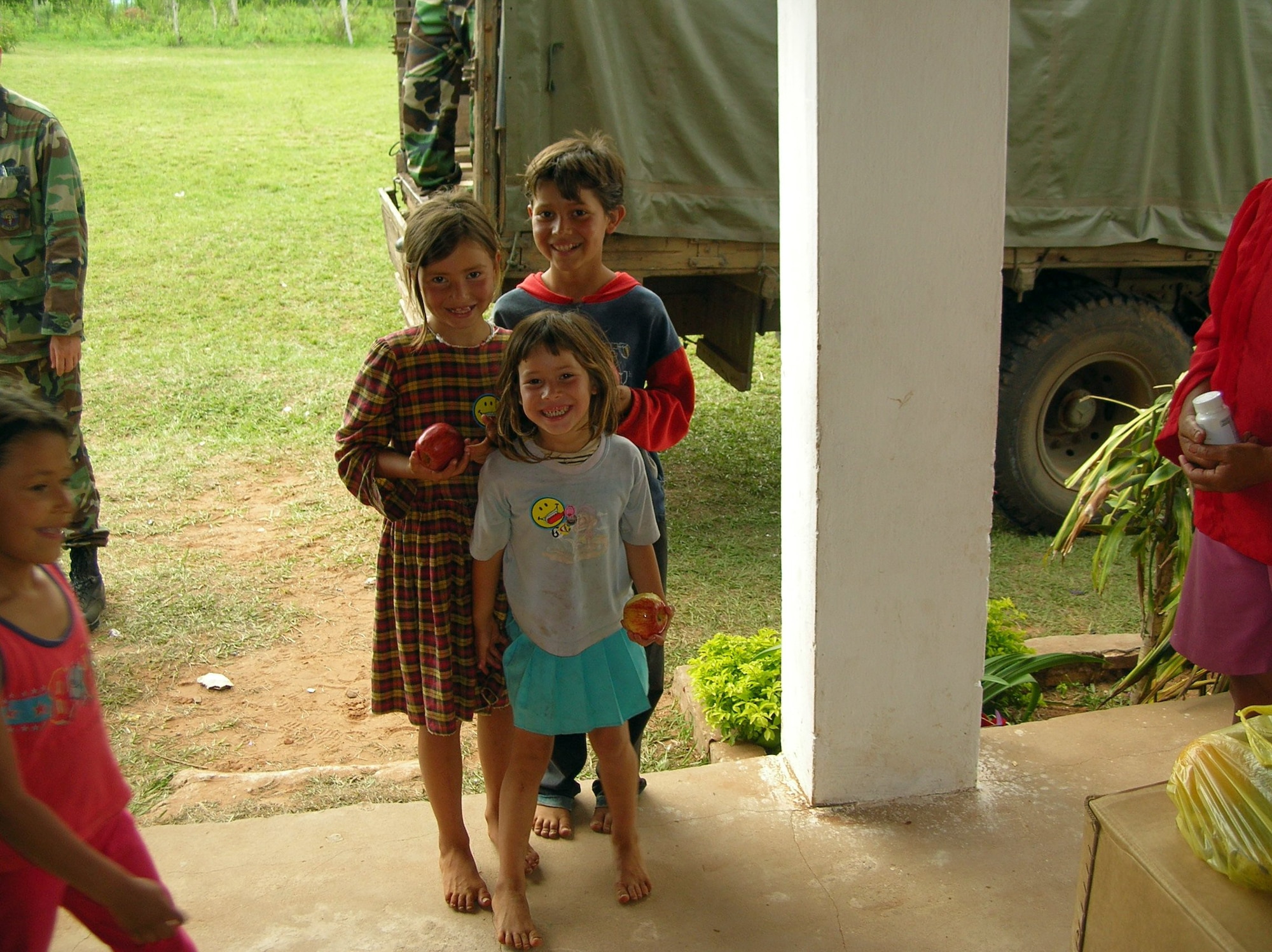 PARAGUAY (AFPN) -- Three Paraguayan children smile for the camera after receiving apples at one of the medical sites set up by Air Force and Paraguayan doctors. (U.S. Air Force photo by Lt. Col. Marc Robins)