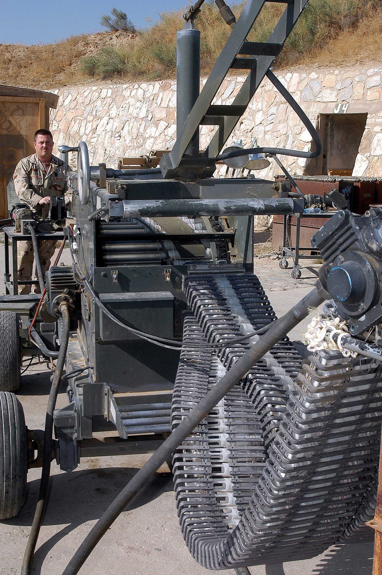 BAGRAM AIR FIELD, Afghanistan (AFPN) -- Tech. Sgt. Todd Wilds processes 30mm high-explosive cannon ammunition here using a GFU-7. The machine, sometimes referred to as the "Dragon," separates the brass from the ammunition downloaded from A-10 Thunderbolts and returns the good rounds to another can, making it reusable for reloading onto the combat aircraft. Since Sept. 15, the 455th munitions flight expended more than 23,000 rounds of 30mm ammunition, 15,000 countermeasures, 103 rockets, 14 500-pound air burst bombs and nine laser-guided bombs in support of the ongoing global war on terrorism. Sergeant Wilds, from Perris, Calif. is deployed from Davis-Monthan Air Force Base, Ariz.  (U.S. Air Force photo by Staff Sgt. Marcus McDonald) 