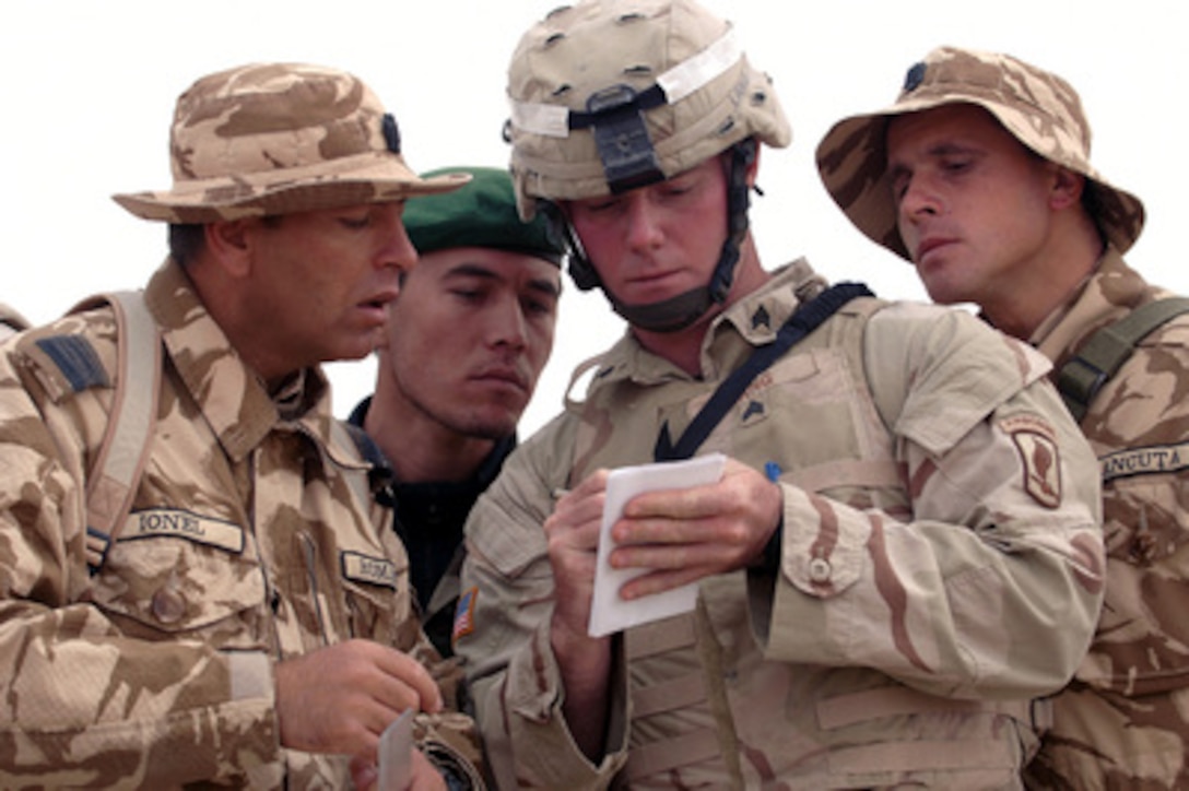 U.S. Army Sgt. Justin Lang (center) writes down the adjustments to be made to the sights of an AK-47 rifle that belongs to Romanian soldier qualifying on the rifle during training at Kandahar Airfield, Afghanistan, on Nov. 14, 2005. Lang is attached to Bravo Company, 1st Battalion, 508th Infantry Airborne Battalion. 