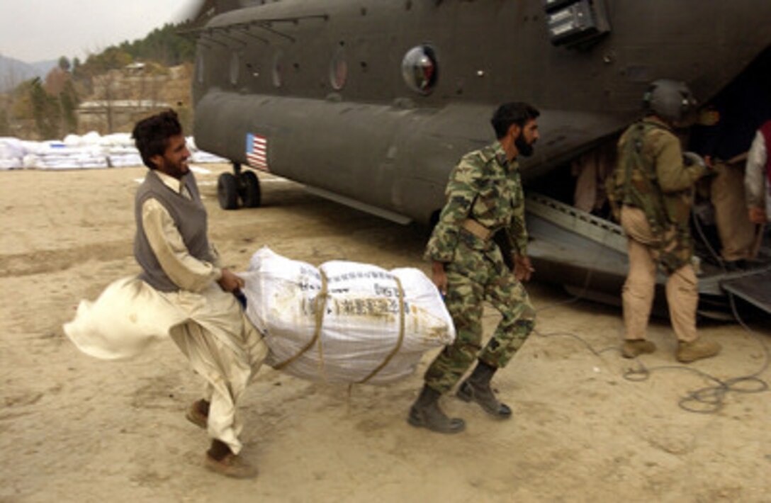Pakistani men load tents into a U.S. Army CH-47D Chinook helicopter in Banna, Pakistan, on Nov. 26, 2005. The Department of Defense is supporting the State Department by providing disaster relief supplies and services following the massive earthquake that struck Pakistan and parts of India and Afghanistan. 