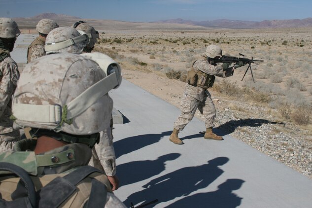 A range coach on Combat Center range 103 shows Marines from Headquarters Company, 7th Marine Regiment, the correct way to fire an M249 Squad Automatic Weapon Nov. 30.  The company has been training for their upcoming deployment to Iraq.