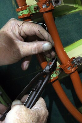 HILL AIR FORCE BASE, Utah (AFPN) -- Robert Touse safety-wires a third stage raceway cable. The cable is used to send command signals throughout the Minuteman III missile. Mr. Touse is an ordnance equipment mechanic in the 309th Missile Maintenance Group. (U.S. Air Force photo by G. A. Volb)