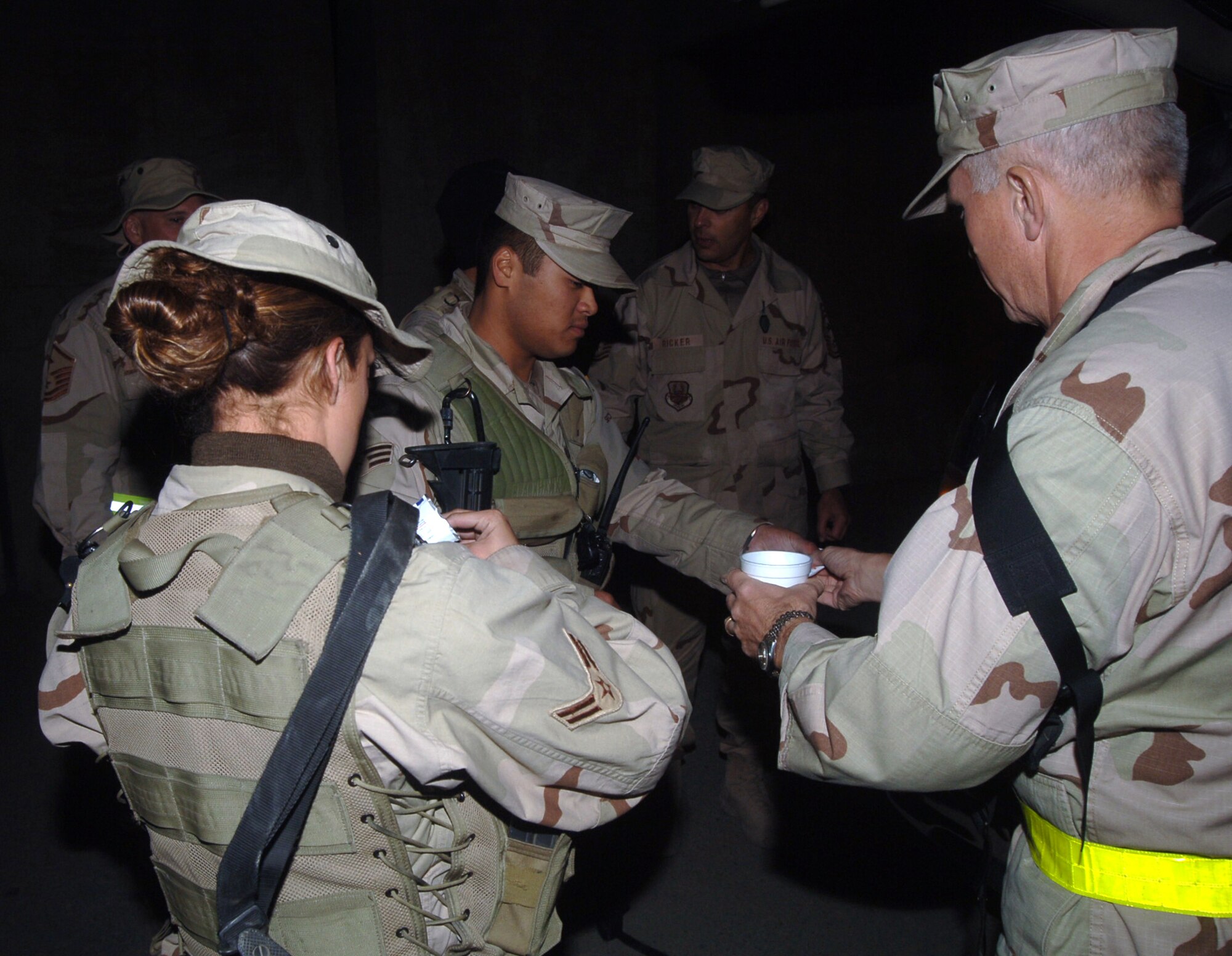 BAGRAM AIRFIELD, Afghanistan (AFPN) -- Brig. Gen. Bruce Burda hands out hot chocolate to Airman 1st Class Chelsea Goodwin (left) and Senior Airman Kenneth Wang. The 455th Air Expeditionary Wing commander, along with his command chief and first sergeants, spent Thanksgiving evening distributing hot chocolate, cookies, candy and hand warmers to Airmen working flightline operations. Airman Wang, from Carrollton, Texas, is deployed from Yokota Air Base, Japan, while Airman Goodwin, from Ceres, Calif., is deployed from Kadena Air Base, Japan. Both are in the 455th Expeditionary Security Forces Squadron.   (U.S. Air Force photo by Staff Sgt. Marcus McDonald)