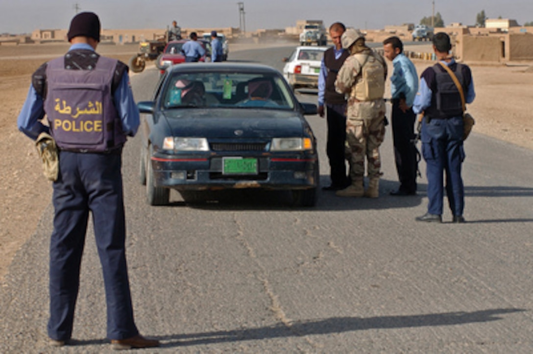 Iraqi police officers and soldiers conduct routine searches at a traffic checkpoint in Bulayz, Iraq, on Nov. 28, 2005. The Iraqi Army soldiers with assistance from U.S. Army soldiers of the 3rd Armored Cavalry Regiment are providing security for the region of Sinjar in order to disrupt insurgent safe havens and to clear weapons cache sights in the area of operation. 