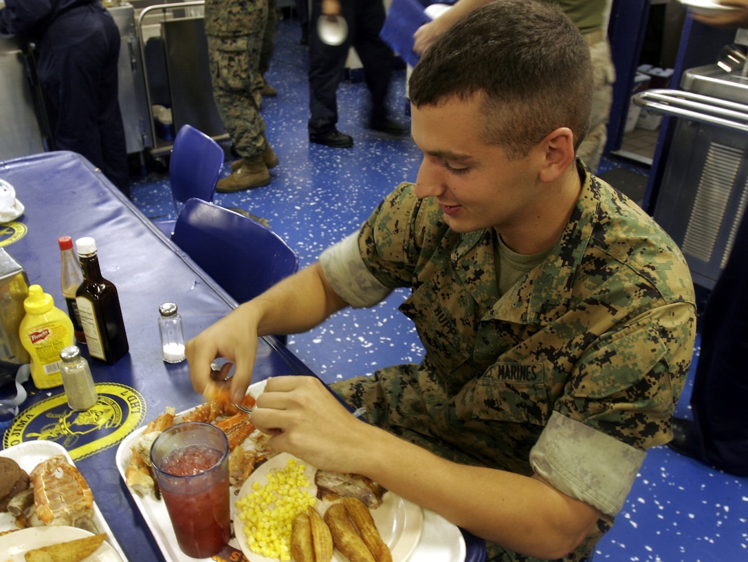 Naperville, Il., native Lance Cpl. Dan A. Hupp, 23, an amphibious assault vehicle crewman, 2nd Amphibious Assault Battalion, 2nd Marine Division, enjoys his final dinner of lobster tail and crab legs aboard USS Iwo Jima. Hupp was one of over 700 Marines embarked aboard the Iwo as part of Special Purpose Marine Air/Ground Task Force St. Bernard's Parish, the Department of Defense response to the catastrophic Hurricane Katrina.